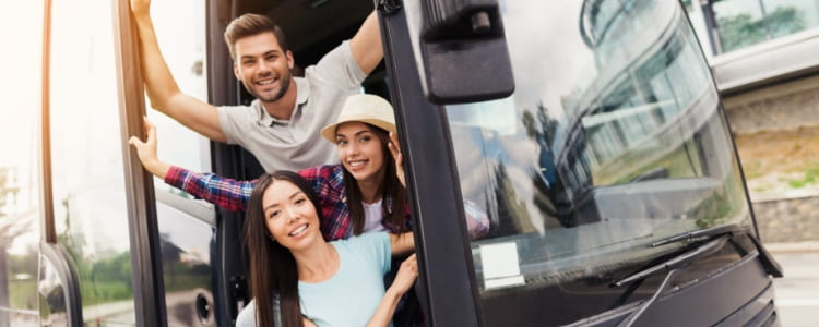 Smiling people getting on bus